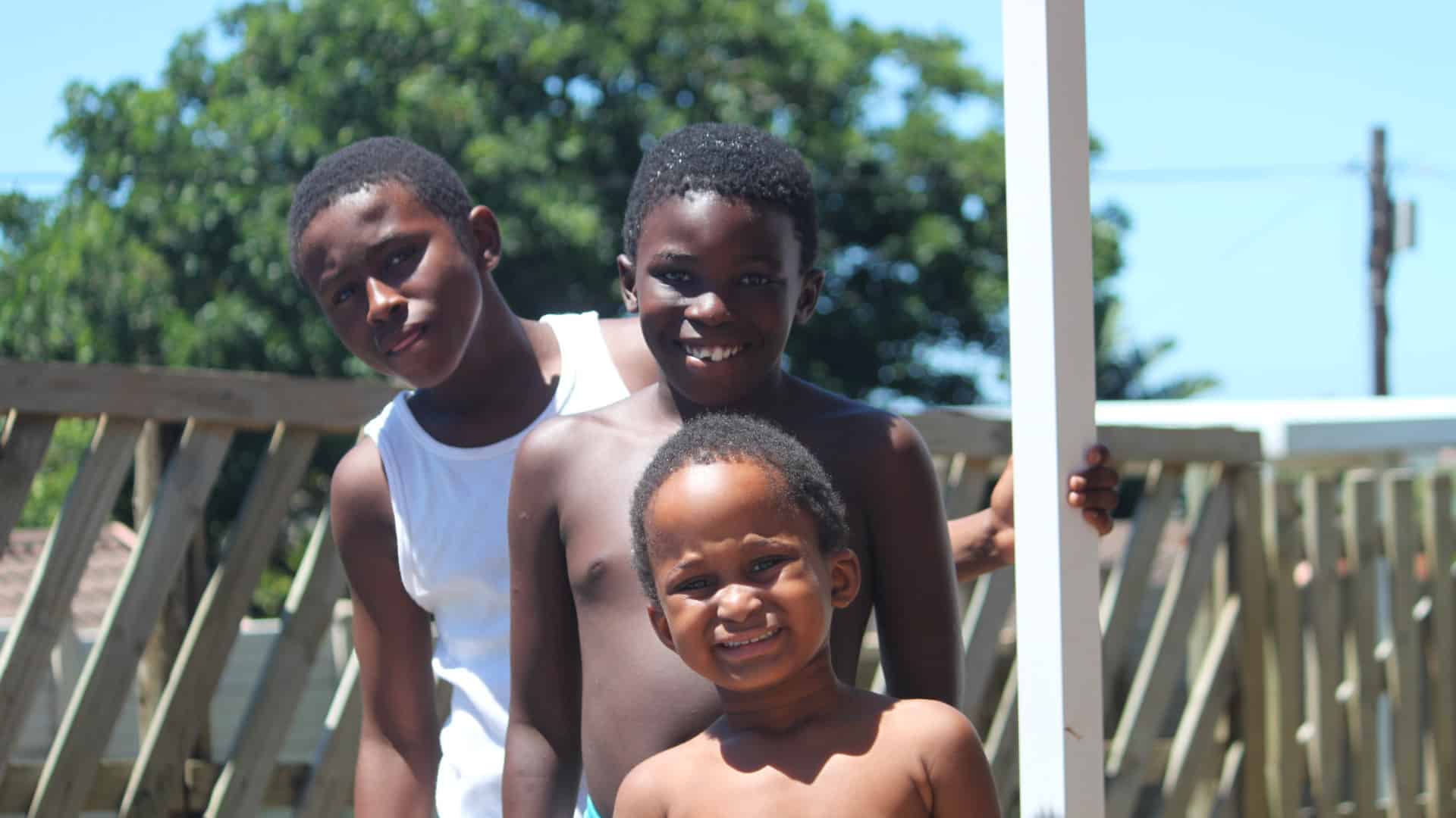 three boys outside posing for the camera